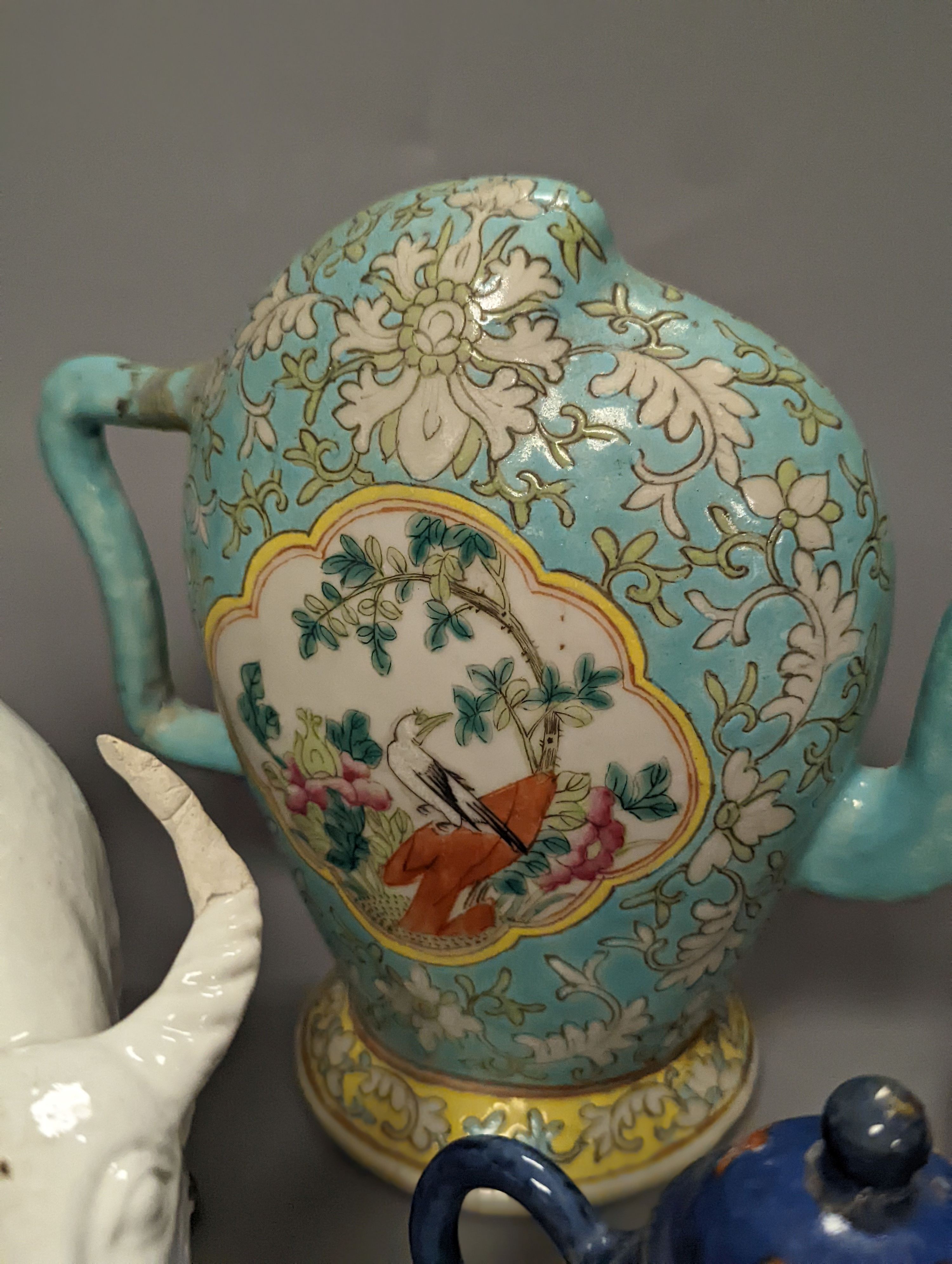 A 19th century Cadogan shape Chinese wine ewer, a Chinese blanc de chine figure riding an ox, an 18th century Chinese miniature blue ground ‘cockerel’ teapot and a Japanese Daikoku figural box and cover. Tallest 19cm